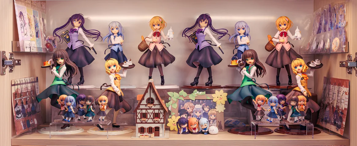 Illuminated display cabinet filled with Is the Order a Rabbit? anime scale figures, chibi figures, acrylic stands, keychains, art prints, and a miniature house.